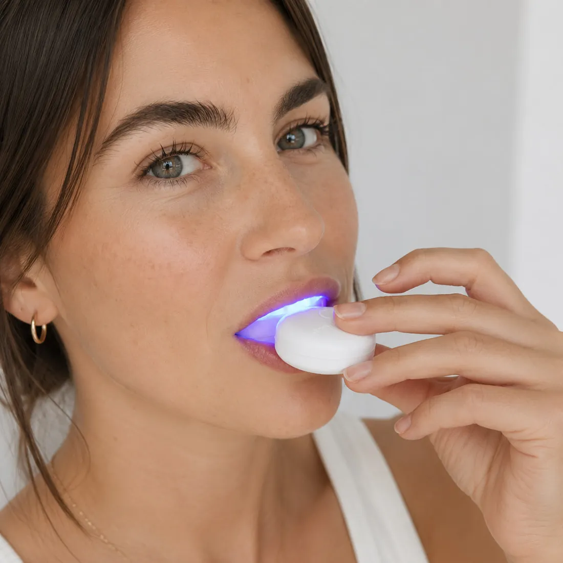A model wearing the SmilePro LED mouthpiece with the light on